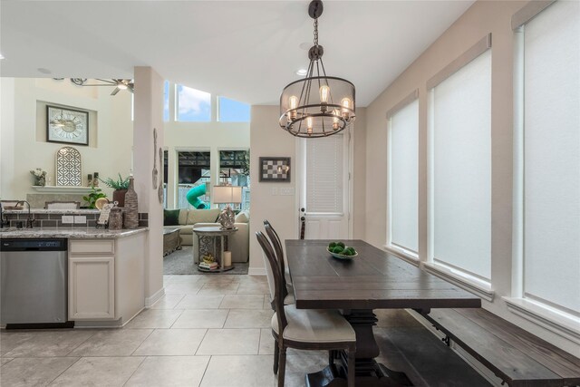 dining room featuring baseboards, ceiling fan with notable chandelier, and light tile patterned flooring