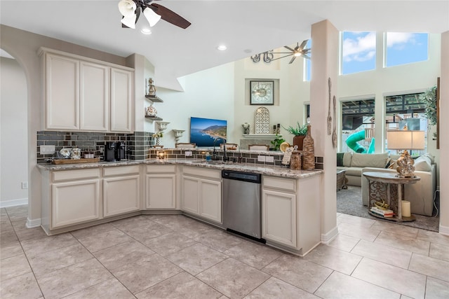 kitchen with dishwasher, arched walkways, a ceiling fan, open floor plan, and a peninsula