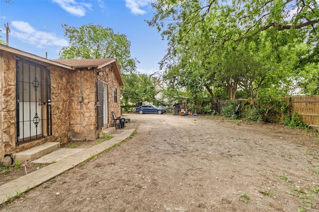 925 New Laredo Hwy, San Antonio, TX 78211 - view of yard featuring fence, driveway, and entry steps