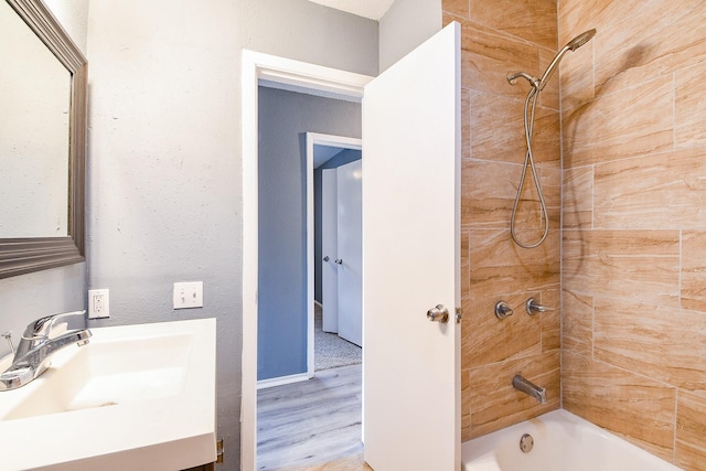 bathroom with shower / bathtub combination, baseboards, wood finished floors, and vanity