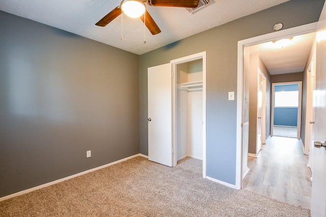 unfurnished bedroom with a closet, baseboards, light colored carpet, and visible vents