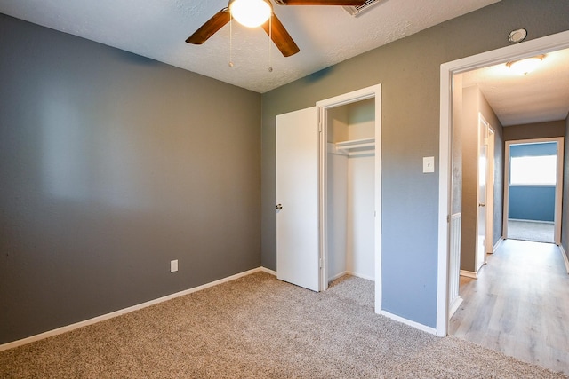 unfurnished bedroom featuring baseboards, carpet flooring, a ceiling fan, and a closet