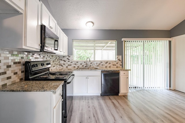 kitchen featuring a sink, light wood-style floors, black appliances, and white cabinetry