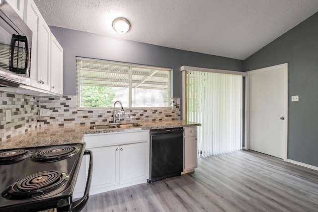 kitchen with backsplash, light wood-type flooring, a sink, white cabinets, and black appliances