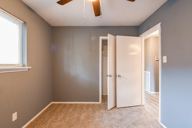 unfurnished bedroom with baseboards, ceiling fan, and carpet