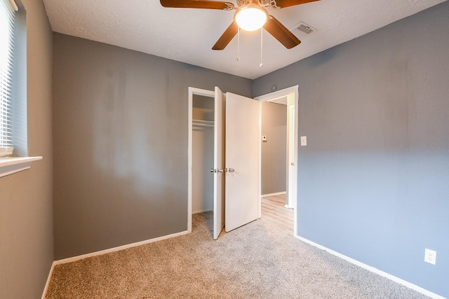 unfurnished bedroom featuring a closet, baseboards, light colored carpet, and visible vents