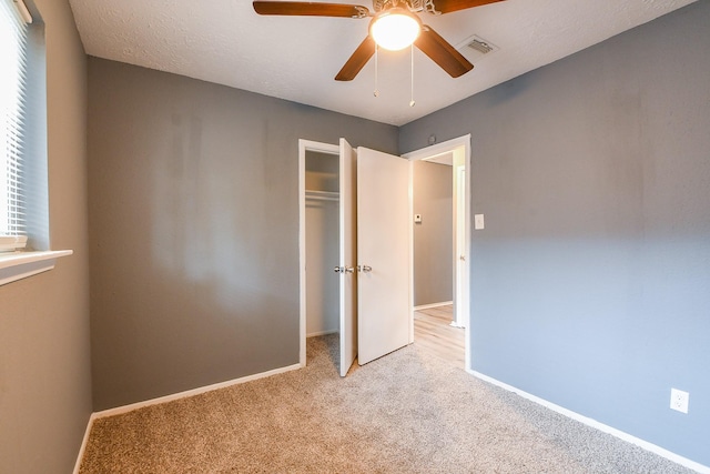 unfurnished bedroom with light carpet, a ceiling fan, baseboards, visible vents, and a closet
