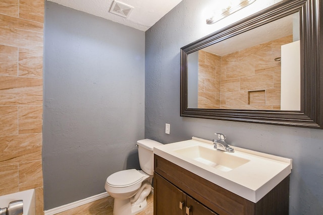 bathroom featuring visible vents, a shower, vanity, baseboards, and toilet