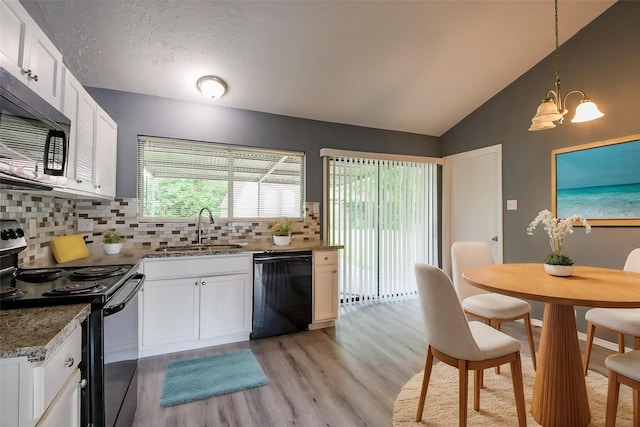 kitchen featuring a notable chandelier, a sink, light wood finished floors, decorative backsplash, and black appliances