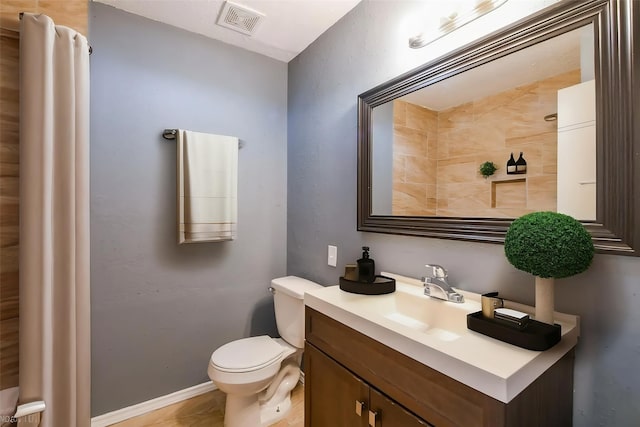 bathroom with toilet, baseboards, visible vents, and vanity