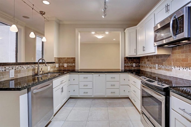 kitchen featuring dark stone counters, white cabinetry, a sink, backsplash, and stainless steel appliances
