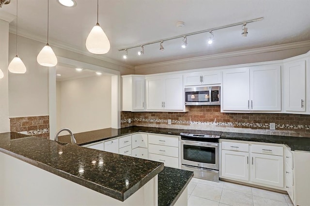 kitchen with dark stone counters, appliances with stainless steel finishes, white cabinets, and ornamental molding