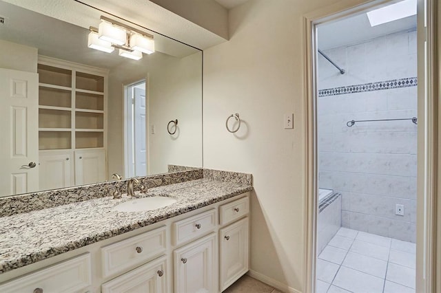 bathroom with walk in shower, vanity, tile patterned floors, baseboards, and a skylight