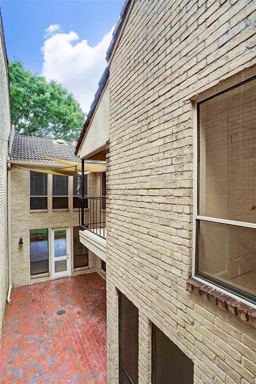 view of side of home featuring brick siding and a patio