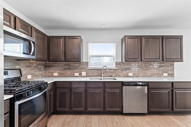 kitchen featuring a sink, light countertops, stainless steel appliances, and dark brown cabinets