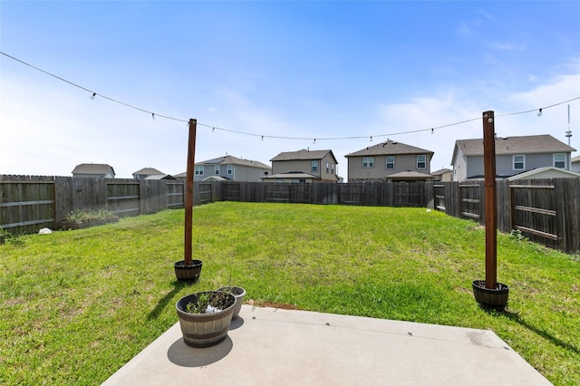 view of yard featuring a fenced backyard, a patio, and a residential view