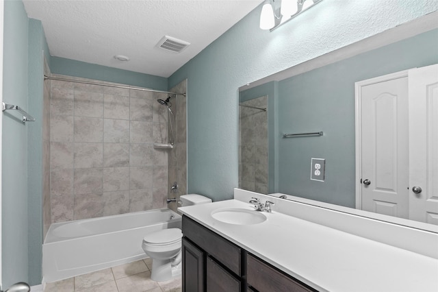 bathroom with vanity, toilet, a textured ceiling, tile patterned floors, and visible vents