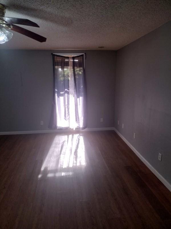 spare room with a textured ceiling, ceiling fan, and wood finished floors