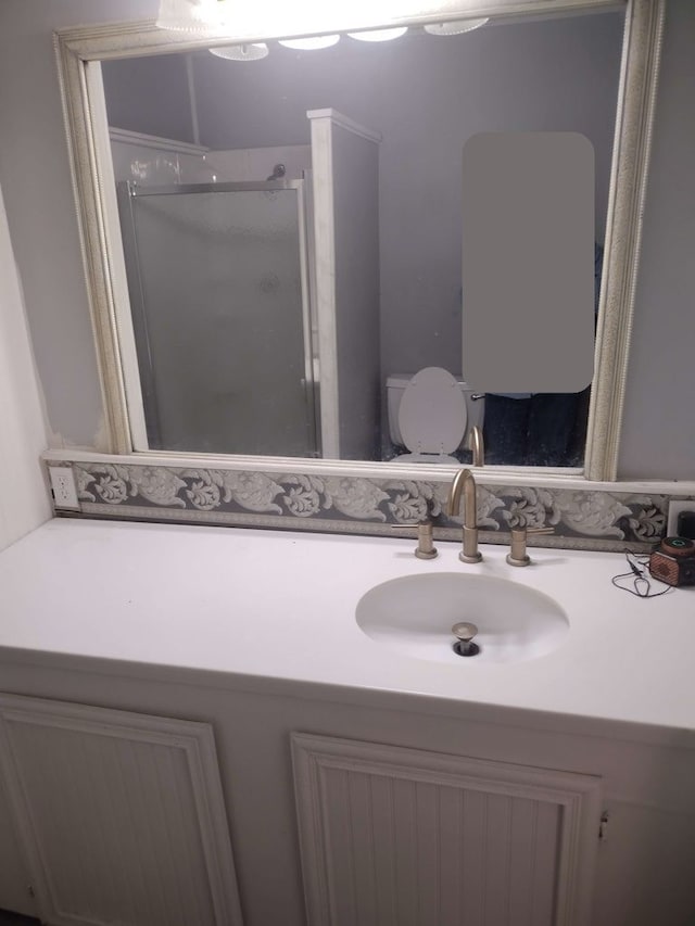bathroom featuring vanity, toilet, and a stall shower