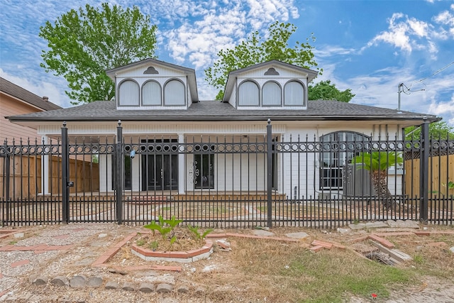 exterior space with roof with shingles and a fenced front yard