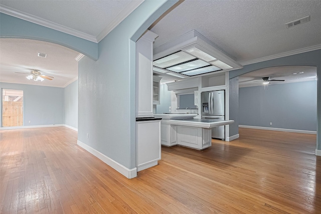 kitchen featuring ceiling fan, stainless steel fridge with ice dispenser, light wood-style floors, open floor plan, and visible vents