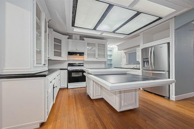 kitchen with under cabinet range hood, white cabinets, range with electric cooktop, and stainless steel fridge with ice dispenser