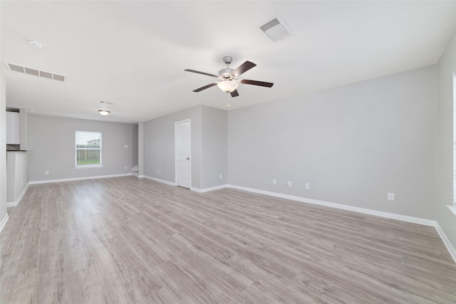empty room featuring baseboards, ceiling fan, visible vents, and light wood-style flooring