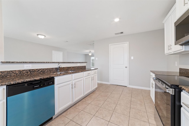 kitchen with a sink, white cabinetry, dark stone counters, and stainless steel appliances