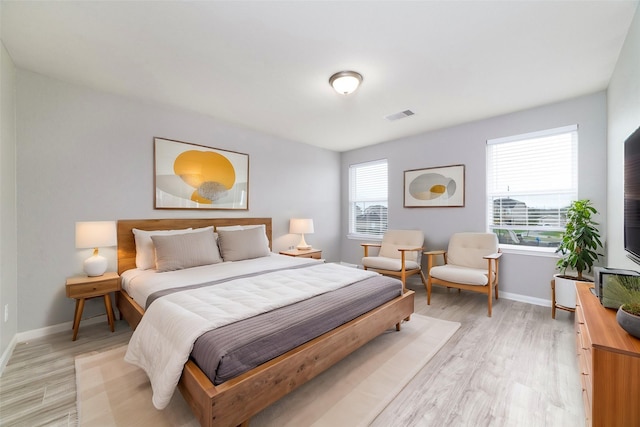 bedroom with baseboards, visible vents, and light wood-style flooring