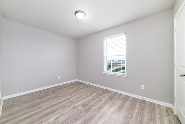 unfurnished room with light wood-type flooring and baseboards
