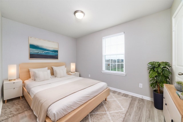bedroom with baseboards and light wood finished floors