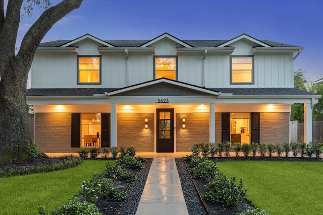 view of front facade featuring covered porch and a front yard