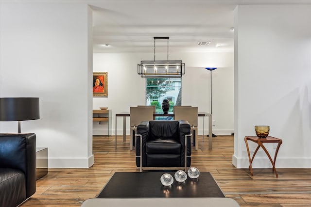 living room featuring baseboards, wood finished floors, and visible vents