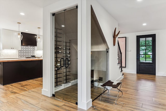 wine area with recessed lighting, baseboards, and light wood-style floors
