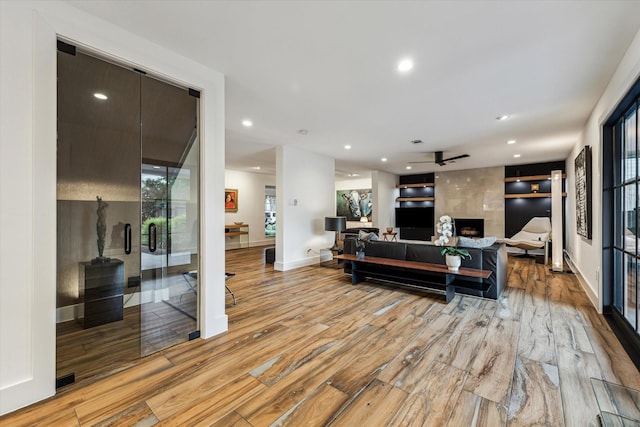 living room with recessed lighting, ceiling fan, and light wood-type flooring
