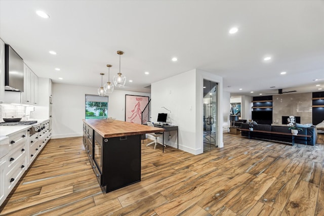 kitchen featuring white cabinets, butcher block countertops, and light wood finished floors