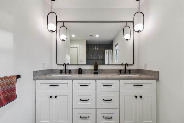 full bath featuring a sink, a shower with shower door, recessed lighting, and double vanity