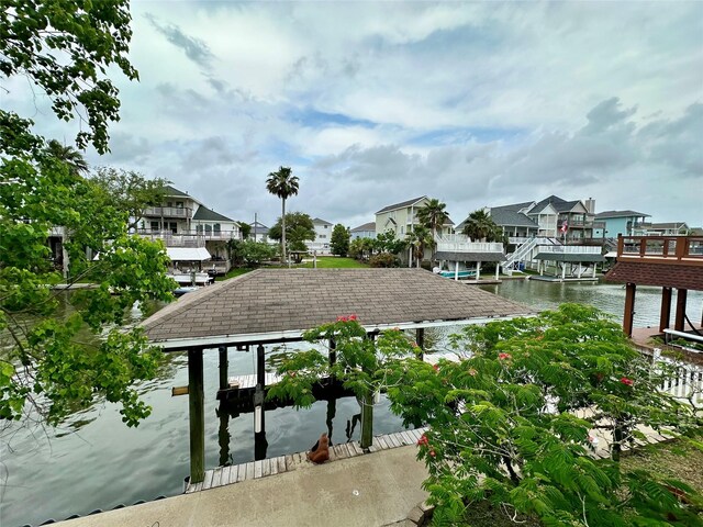 12828 E Madrid, Galveston, TX 77554 - view of dock featuring boat lift, a water view, and a residential view
