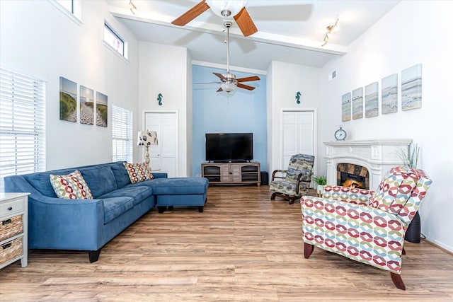 12828 E Madrid, Galveston, TX 77554 - living area with light wood-style floors, a ceiling fan, rail lighting, and high vaulted ceiling