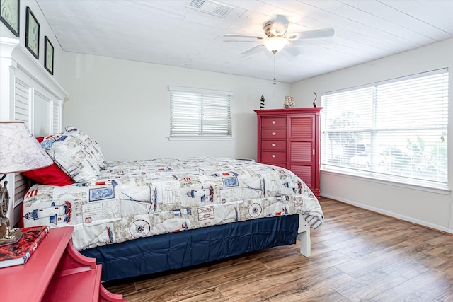 12828 E Madrid, Galveston, TX 77554 - bedroom with baseboards, visible vents, multiple windows, and wood finished floors