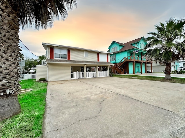 12828 E Madrid, Galveston, TX 77554 - view of front of house with fence, driveway, and stairway