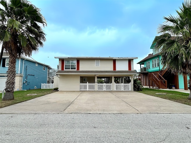 12828 E Madrid, Galveston, TX 77554 - view of front facade featuring fence, concrete driveway, and stairway