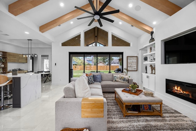 living room with ceiling fan, beam ceiling, a glass covered fireplace, built in shelves, and recessed lighting