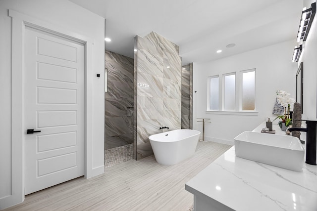 bathroom featuring vanity, recessed lighting, a marble finish shower, and a soaking tub