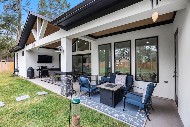 view of patio with area for grilling, fence, and an outdoor fire pit