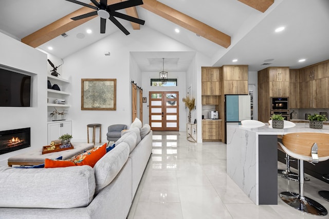 living area featuring recessed lighting, a glass covered fireplace, beam ceiling, and high vaulted ceiling