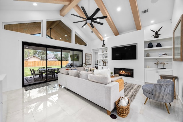 living room featuring a glass covered fireplace, built in shelves, a ceiling fan, vaulted ceiling with beams, and visible vents
