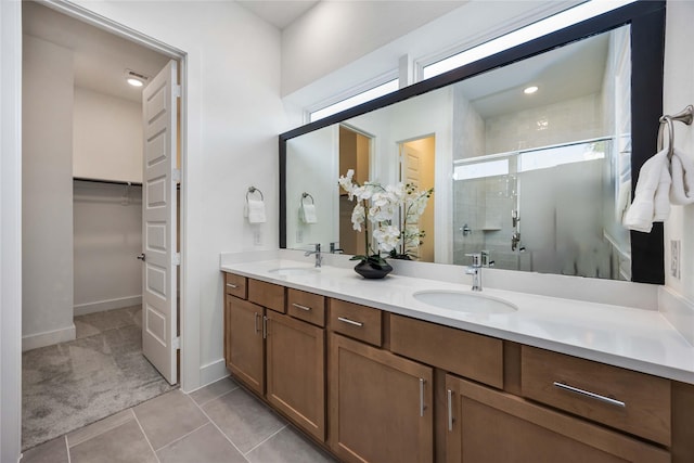 bathroom featuring a sink, tile patterned flooring, a walk in closet, and a shower stall