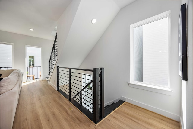 stairway featuring baseboards, vaulted ceiling, recessed lighting, and wood finished floors