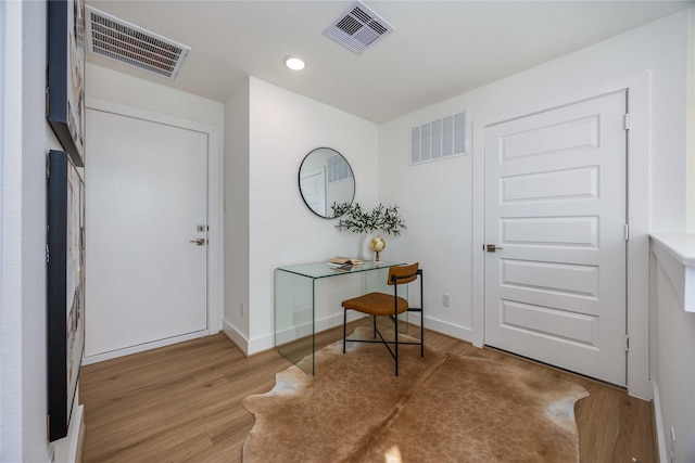 foyer entrance with visible vents and wood finished floors